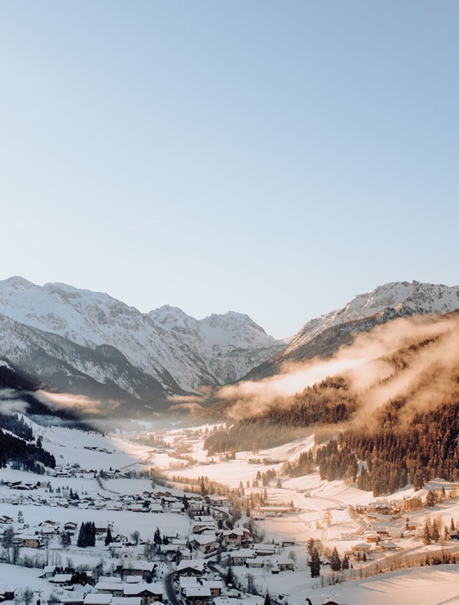 Blick über das schneebedeckte Kleinarltal in der Morgensonne