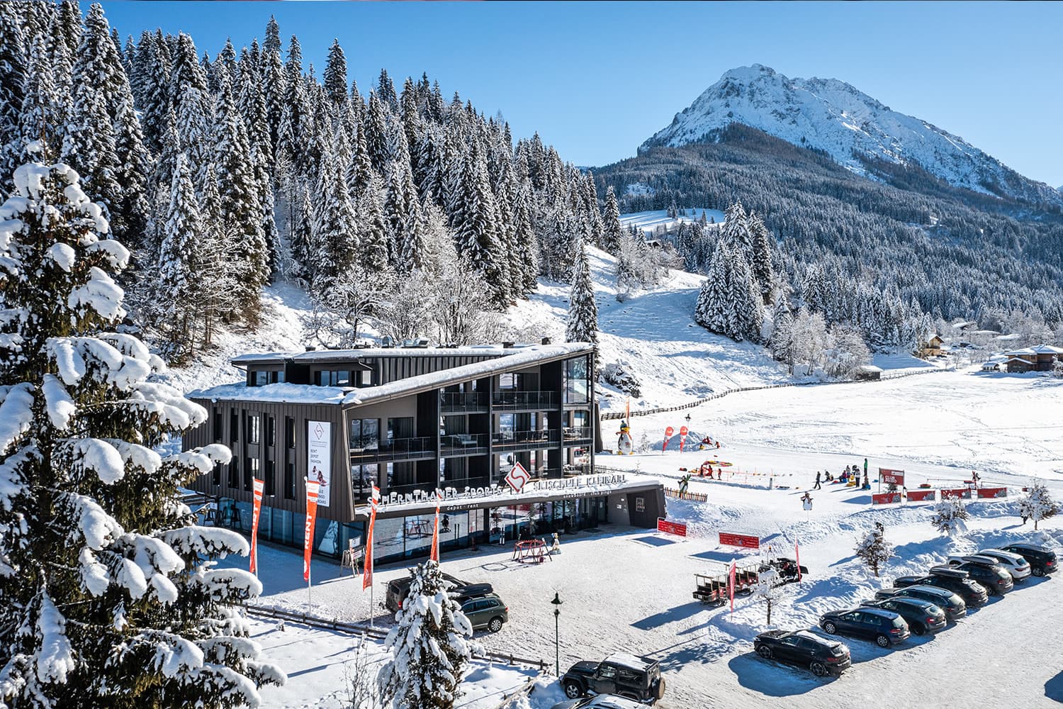 Skischule und Snowboardschule Kleinarl mit Sammelplatz und Erlebniswiese sowie Blick auf die verschneiten Berge